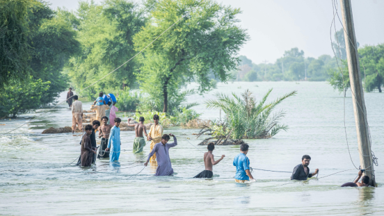 Men wading through flood waters. 